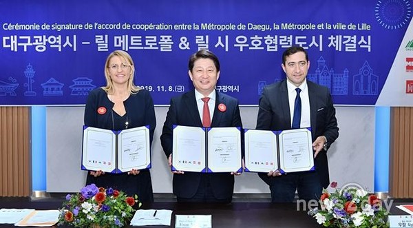 권영진 대구시장이 8일 프랑스 릴 시 관계자들과 우호협력도시 협약을 체결한 뒤 협약서를 들어보이고 있다(사진=대구시)