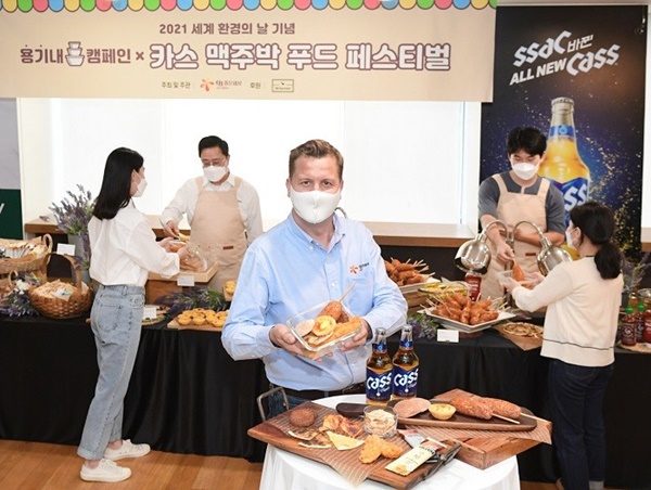 오비맥주 배하준 대표(가운데)가 강남구 오비맥주 본사에서 지난 6월 개최한 ‘카스 맥주박 업사이클링 푸드 페스티벌’에서 직접 챙겨온 용기에 맥주박 푸드를 담고 기념 촬영을 하고 있다. 오비맥주의 협력사인 푸드 전문 스타트업 리하베스트는 후원사로 이번 행사에 참여했다./사진=오비맥주 