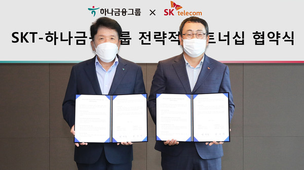 하나금융그룹과 SK텔레콤은 지난 22일 서울 중구 을지로 SK텔레콤 사옥에서 전략적 파트너십을 체결했다고 밝혔다. 이날 전략적 파트너십 협약식에 참석한 함영주(왼쪽) 하나금융그룹 회장과 유영상 SK텔레콤 사장이 협약서를 펼쳐보이며 기념 촬영을 하고 있다.