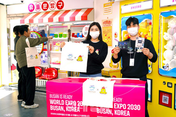  LG유플러스 임직원이 부산 서면에 위치한 언택트스토어에서 방문 고객에게 에코백을 선물하며 2030부산세계박람회 유치를 응원하고 있는 모습/사진=LG유플러스