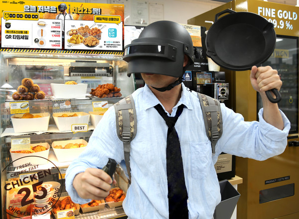 GS25에서 모델이 배틀그라운드 소품을 착용하고 포즈를 취하고 있다/사진=GS리테일