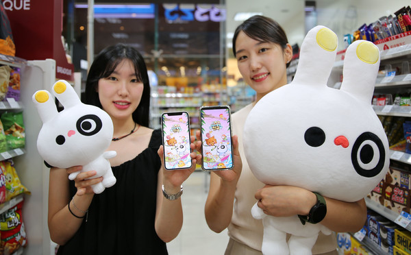 모델들이 GS25에서 미니게임천국 캐릭터 인형과 휴대폰을 들고 포즈를 취하고 있다/사진=GS25