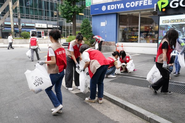 롯데면세점이 지난 30일 서울시 중구 명동 일대에서 ‘줍깅 릴레이 캠페인’을 진행했다. 사진은 롯데면세점 임직원들이 거리에서 쓰레기를 수거하는 모습/사진=롯데면세점
