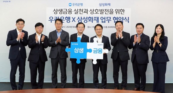 (왼쪽부터) 박용성 우리은행 미래고객전담추진ACT장, 성병용 우리은행 상생금융부장, 김범석 우리은행 국내영업부문장, 조병규 우리은행장, 이문화 삼성화재 사장, 고기호 삼성화재 디지털본부장, 김태윤 삼성화재 디지털마케팅팀장, 박지현 삼성화재 디지털장기일반영업부장이 협약식에서 상생금융 퍼즐을 맞추며 기념사진을 촬영하고 있다. /사진=우리은행 제공