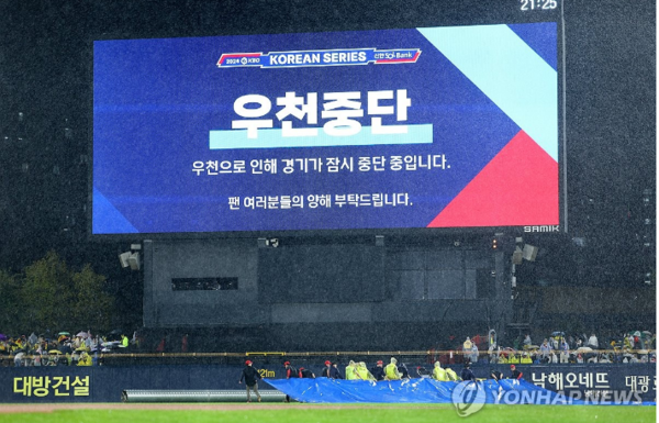  21일 광주 기아챔피언스필드에서 열린 2024 신한 SOL 뱅크 KBO 포스트시즌 한국시리즈 1차전 삼성 라이온즈와 KIA 타이거즈의 경기. 6회초 강한 비로 경기가 잠시 중단되자 경기장 관계자들이 방수포를 경기장에 덮고 있다. /사진=연합뉴스.