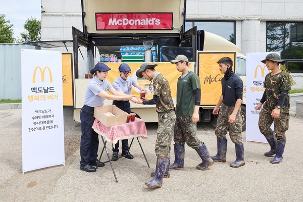 가평 지역 수해 복구에 참여한 군 장병들이 맥카페 음료트럭 앞에서 버거와 음료를 수령하고 있다/사진=맥도날드