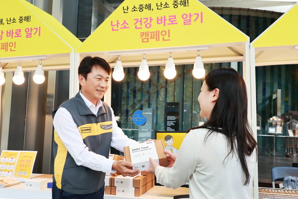 KB손해보험 구본욱 사장(왼쪽)이 행사에 참여한 여성에게 난소 나이 자가검사 진단 키트를 전달하고 있다./사진=KB손해보험