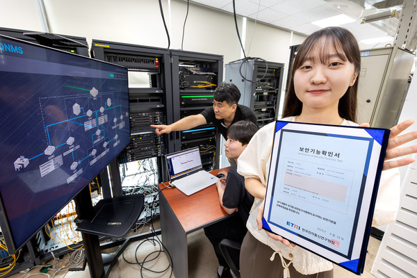 KT와 코위버 직원이 양자키분배 기술 적용 장비를 점검하며 보안 인증서를 소개하는 모습/사진=KT