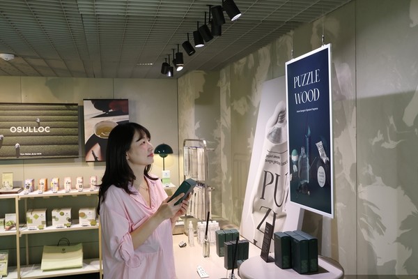 아모레성수 굿즈존에서 삼성 컬러 이페이퍼에 표시된 내용을 살펴보는 방문객/사진=삼성전자