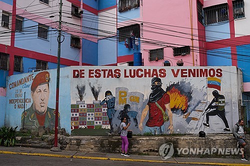 11일(현지시간) 베네수엘라 좌파 지도자 우고 차베스 벽화(왼쪽)와 투쟁 의지를 고취하는 글귀/사진=카라카스 AP 연합뉴스